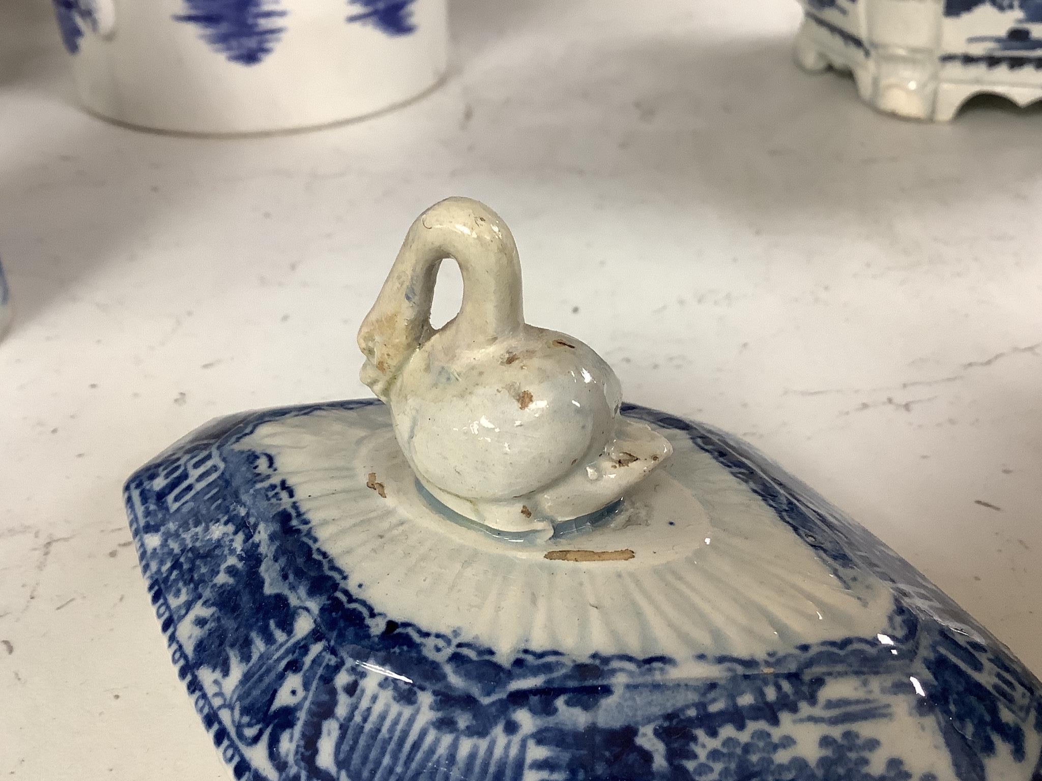 A collection of English blue and white pottery, various dates, comprising a moulded hexagonal teapot and cover, with widow finial, ovoid teapot and cover, lozenge section sugar bowl and cover, with swan finial, circular